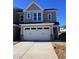 New construction two-story home featuring a two-car garage, concrete driveway and neutral gray siding at 8951 Kennebec Crossing Dr # 51, Angier, NC 27501