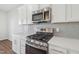 Close-up of a modern kitchen with stainless steel appliances and gray backsplash tiles at 907 Montague Ave, Durham, NC 27703