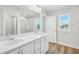 Bright bathroom featuring a double sink vanity, large mirror, and tiled shower with glass doors at 911 Montague Ave, Durham, NC 27703