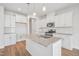 Bright, modern kitchen features an island, stainless steel appliances, and white cabinetry at 911 Montague Ave, Durham, NC 27703
