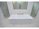 Free-standing soaking tub with marble tile and gold fixtures at 914 Ardmore Dr, Durham, NC 27713