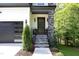 Modern front entrance with stone pillars, wood door, and metal railing at 914 Ardmore Dr, Durham, NC 27713
