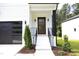 Stylish front entry with a modern wood door and black metal railings at 916 Ardmore Dr, Durham, NC 27713