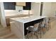 Kitchen island with white marble countertop and four gray woven barstools at 916 Ardmore Dr, Durham, NC 27713