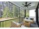 Relaxing screened porch with wooded views, ceiling fan, and comfortable seating area at 916 Ardmore Dr, Durham, NC 27713