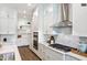 White kitchen with stainless steel appliances and marble-look backsplash at 1 Kelsey Ct, Hillsborough, NC 27278
