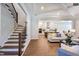 Elegant staircase with dark wood railing opens to the kitchen and living area at 1 Kelsey Ct, Hillsborough, NC 27278