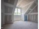 An attic bedroom featuring a window overlooking lush green trees at 1117 Delilia Ln, Wake Forest, NC 27587