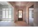 Entryway featuring a wood door with glass panels, freshly drywalled walls, and natural light streaming through the windows at 1117 Delilia Ln, Wake Forest, NC 27587