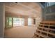 Open-concept living area showcasing access to the backyard, drywalled walls, and staircase awaiting finishing touches at 1117 Delilia Ln, Wake Forest, NC 27587