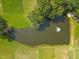 An aerial image shows a pond in a community with a fountain and trees at 1117 Delilia Ln, Wake Forest, NC 27587
