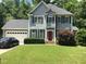Two-story house, gray siding, red door, attached garage, and yard at 300 Ashwick Dr, Efland, NC 27243