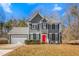 Two-story gray house with a red door, white garage door, and landscaping at 300 Ashwick Dr, Efland, NC 27243