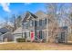 Two-story gray house with a red door, white garage door, and landscaping at 300 Ashwick Dr, Efland, NC 27243