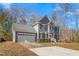 Two-story gray house with a red door, white garage door, and landscaping at 300 Ashwick Dr, Efland, NC 27243