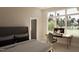 Bright bedroom featuring an inviting desk and chair setup in front of a large window with views of the yard at 403 Carolyn Ct, Cary, NC 27511