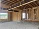 New construction garage interior featuring wood studs and steel I beam, with gravel floor and open window at 403 Carolyn Ct, Cary, NC 27511