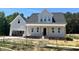 New two-story home with gray siding, a front porch, and an attached two-car garage at 404 Brodie Rose Landing Way, Smithfield, NC 27577