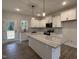 Modern kitchen with large island, granite countertops, white cabinets, and stainless steel appliances at 404 Brodie Rose Landing Way, Smithfield, NC 27577