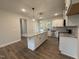 Bright kitchen with island, white cabinets, granite countertops, and stainless steel appliances at 404 Brodie Rose Landing Way, Smithfield, NC 27577