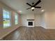 Open-concept living room with modern fireplace and ample natural light from the large windows at 404 Brodie Rose Landing Way, Smithfield, NC 27577