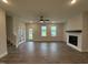 Spacious living room features a modern fireplace, ceiling fan, and windows that bring in plenty of natural light at 404 Brodie Rose Landing Way, Smithfield, NC 27577