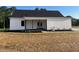 Home featuring a covered porch with wood columns, back yard, and white siding at 541 Delma Grimes Rd, Coats, NC 27521
