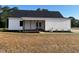 Backyard featuring a covered porch with wooden columns, white siding, and manicured lawn at 541 Delma Grimes Rd, Coats, NC 27521