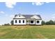 Beautifully landscaped modern farmhouse-style home with a lush, green front yard on a sunny day at 541 Delma Grimes Rd, Coats, NC 27521