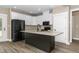 Modern kitchen with a center island, granite countertops, white cabinets, and stainless steel appliances at 541 Delma Grimes Rd, Coats, NC 27521