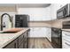 Close-up of a modern kitchen with granite countertops, white cabinets and stainless steel appliances at 541 Delma Grimes Rd, Coats, NC 27521