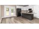 Modern kitchen with a center island, granite countertops, white cabinets, and stainless steel appliances at 541 Delma Grimes Rd, Coats, NC 27521