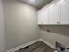 Functional laundry room with built in white cabinets and neutral paint at 541 Delma Grimes Rd, Coats, NC 27521