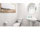 Clean powder room with pedestal sink, toilet and framed art at 6012 Sodium St, Raleigh, NC 27610