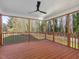 Large, covered deck with a ceiling fan and wood flooring overlooking a wooded lot at 624 S Eighth St, Mebane, NC 27302