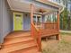 Inviting front porch with wood floors, stairs, and a vibrant yellow front door at 624 S Eighth St, Mebane, NC 27302