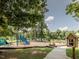 Community playground featuring slides, climbing structures, and a little free library in a park-like setting at 624 S Eighth St, Mebane, NC 27302