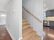 Wooden stairway leading to the second floor, with a view of the kitchen at 624 S Eighth St, Mebane, NC 27302
