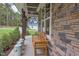 Front porch with stone facade, wooden bench, and potted plants at 63 Rice Rd # 01, Zebulon, NC 27597