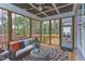 Spacious screened porch, wicker furniture, wooded views, and access to deck at 63 Rice Rd # 01, Zebulon, NC 27597