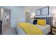 Bright bedroom showcasing a plush bed with yellow accents and modern decor at 664 Morning Glade St, Wake Forest, NC 27587