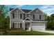 Two-story house with gray siding, brick accents, and a two-car garage at 664 Morning Glade St, Wake Forest, NC 27587