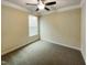 Empty bedroom with neutral walls and carpet, featuring a window with blinds at 7434 Randshire Way, Raleigh, NC 27616