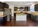 Kitchen with dark cabinets, granite countertops, stainless steel appliances, and hardwood floors at 7434 Randshire Way, Raleigh, NC 27616