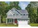 Charming two-story home featuring a red front door, gray siding, and a two-car garage at 8817 Tartan Clan Dr, Angier, NC 27592