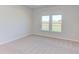 Carpeted bedroom with large window and neutral walls at 104 Barn Door Dr, Lillington, NC 27546
