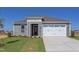 Gray house with white garage doors and landscaping at 104 Barn Door Dr, Lillington, NC 27546