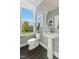 Stylish powder room featuring designer wallpaper, pedestal sink, and a window with a view of the green outdoors at 107 Ailey Brook Way # 200, Wake Forest, NC 27587