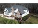 An aerial view of a house with stone and siding, a well-manicured lawn, and mature trees at 1201 Rivermead Ln, Wake Forest, NC 27587