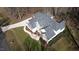 An aerial view of a house with stone and siding, a well-manicured lawn, and mature trees at 1201 Rivermead Ln, Wake Forest, NC 27587